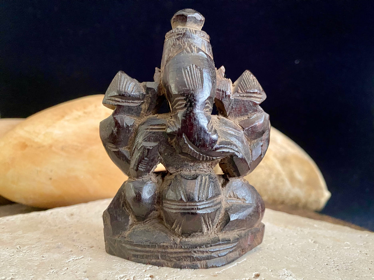 Small rosewood carving of Ganesh. Early 1900's, from east India. Two arms, seated, with his trunk to the left.  Height 9.5 cm, width  7 cm