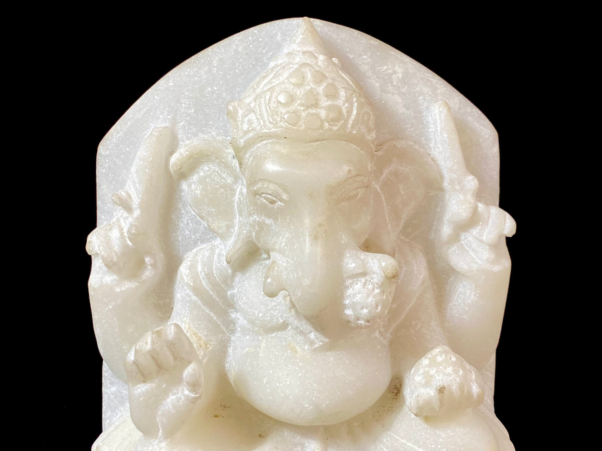 Hand carved marble stone statue of Ganesh. Our Ganesh sits on a lotus pedestal, while his mouse sits at his feet. One of his right hands is upraised in the gesture of protection, while the other holds his favourite ladoo sweet. Measurements: 22 cm high, 14 cm wide, 6 cm depth