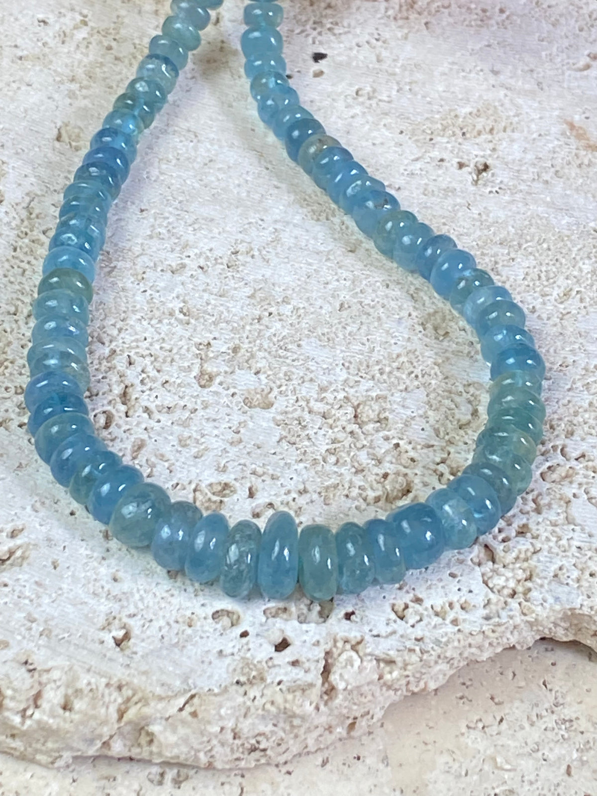 Natural aquamarine necklace featuring rondel cut graduated aquamarine. Sterling silver hook and ring clasp. The aquamarine beads are matched, graduated, 100% natural, of a deep cloudy sea blue. Measurements: 41.5 cm