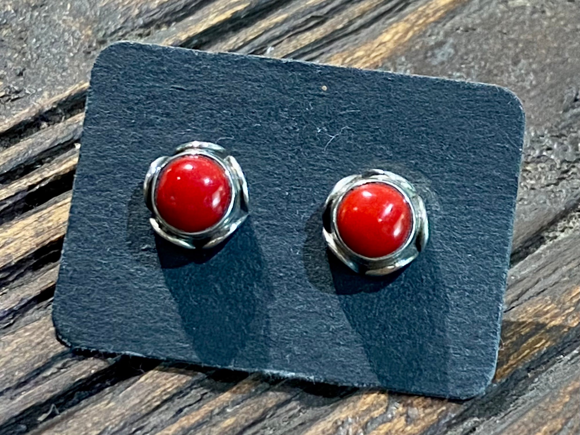 large coral and silver stud earrings featuring a patterned silver bezel