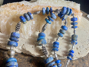 Tribal lapis lazuli and silver necklace, crafted from antique unpolished graduated Afghani lapis lazuli and handmade, vintage and antique tribal silver beads. This stunning, long necklace is finished with a sterling silver clasp and weighs 170 g. Measurements: 68 cm in length