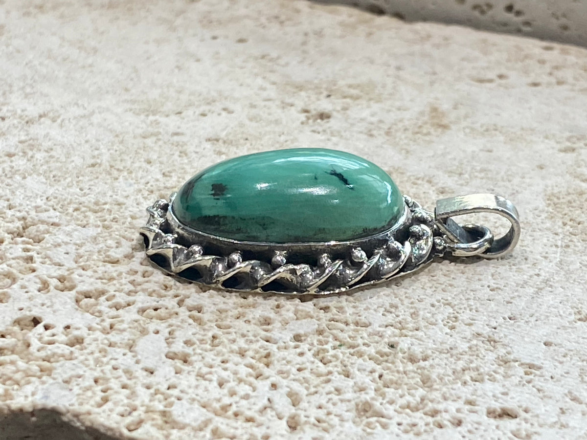 Arizona turquoise pendant set off by a detailed sterling silver bezel, with an enclosed silver back, topped by a large bail large. Measurements: 4.6 cm height including bail, width 2.2 cm