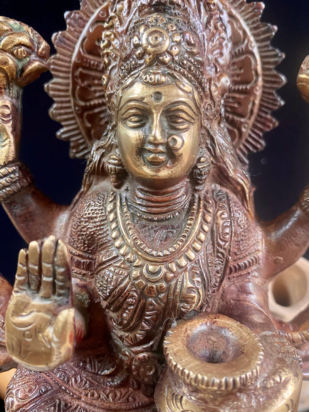 A statue of the goddess Laxmi (or Lakshmi), Hindu goddess of wealth and prosperity. Cast from solid brass, her features are exquisitely detailed, while her face, hands and feet are polished. Her right hand is raised in the gesture of protection and her left hand holds a pot symbolising abundance. Measurements: 19.8 cm height, width12 cm, depth 8.3 cm