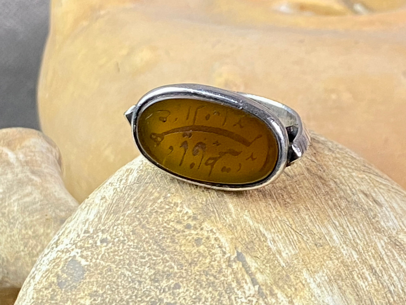 Afghani ring features an antique honey-coloured engraved carnelian prayer plaque set into a new silver band. Sits high on the finger and is a statement piece. High grade or sterling silver has been used to make the ring band. Men or women's ring. Measurements: Carnelian 2.4 x 1.4 cm, inner diameter 19.75 mm | Size 10