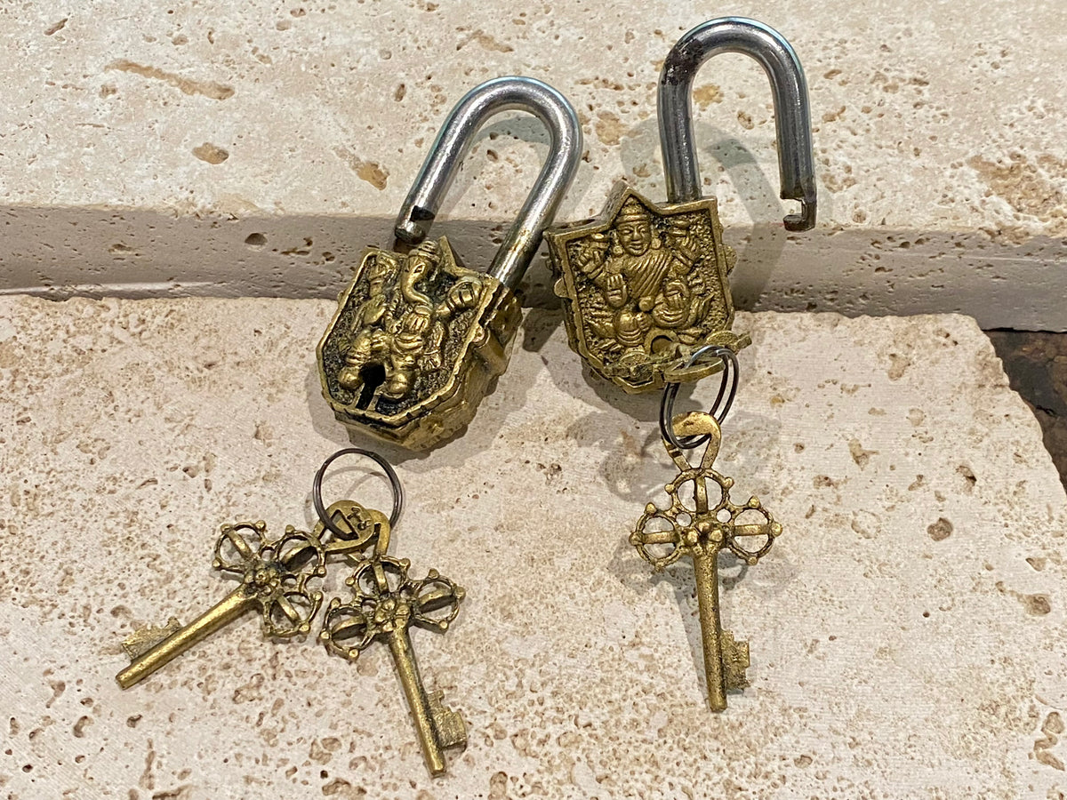 Small brass Indian deity padlocks embossed with the image of Ganesh or Laxmi. to keep your possessions safe and blessed. On the back is the Om, powerful Buddhist protective symbol. Two keys provided with every lock. On the top of each is the viswa vajra, a Buddhist protective symbol. Measurements: height 6.5 cm, width 3 cm, depth 1.5 cm