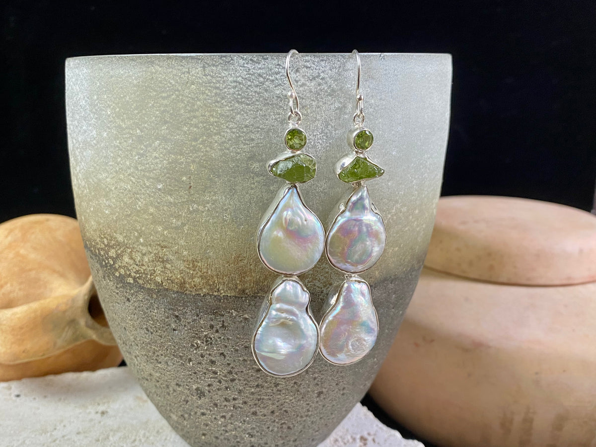 Very long earrings featuring cultured baroque pearls and peridot stones. These statement earrings are set in sterling silver, with sterling silver shepherd hooks. 8 cm length including hooks, width approximately 1.8 cm, depth 0.5 cm