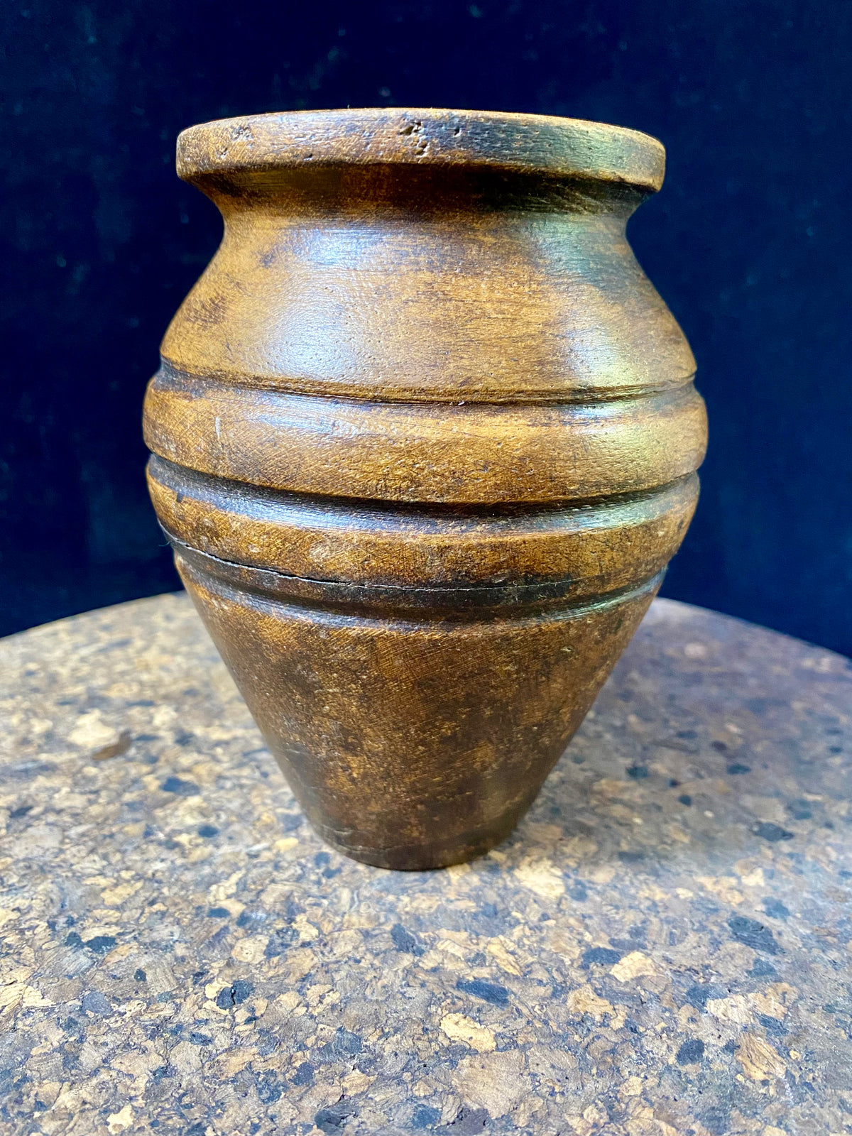 A small shaped wood pot with three carved lines of decoration. Carved from hardwood, most likely rosewood. Late 20th century vintage. Measurements: diameter at widest point 9 cm, diameter of opening 4.5 cm, height 12 cm