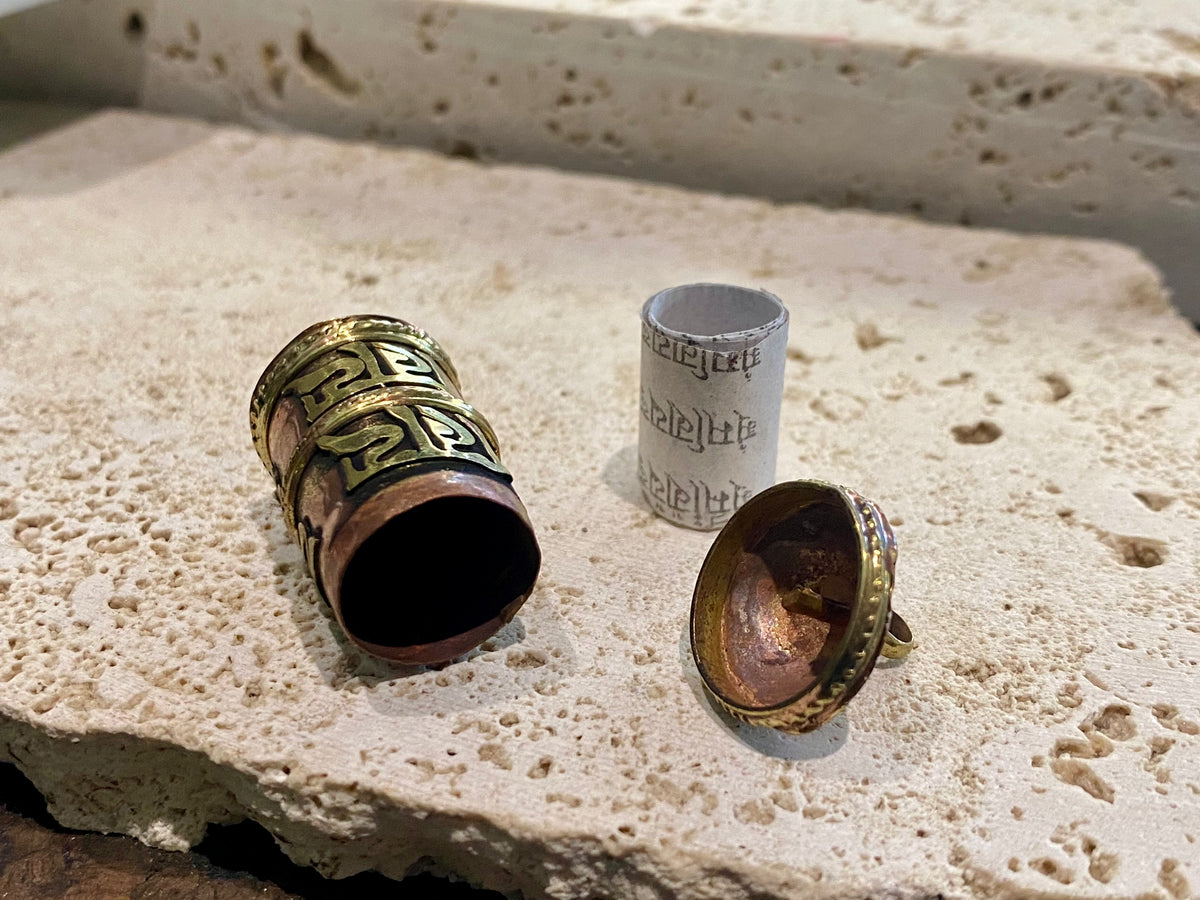 These copper and brass prayer boxes or amulets are designed to be worn as a pendant, or added to a keyring. Contains a prayer scroll withthe mantra to the Compassionate Buddha Om Mani Padme Hum , 4.5 cm length
