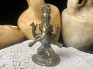 This exquisite miniature Ganesh statue features fine, elegant features, a face rubbed through many years of worship and a high tribal headdress typical of the eastern states of India. Early 20th century, India, bronze alloy.  Measurements: height 6.5 cm, width 3.2 cm, depth 2.5 cm