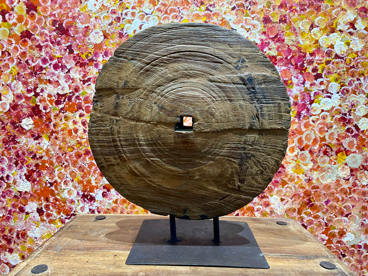 This lovely wooden pulley or spinning wheel, made from solid teak, stands on an iron stand and is repurposed as a piece of art. Originating from northern India and dating back to the early 20th century. Measurements: diameter 33cm, height 37.5cm, depth width of stand 8 cm