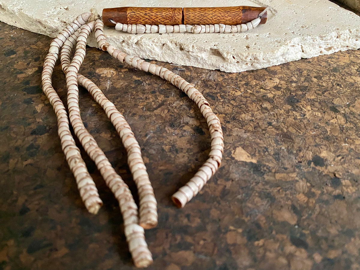 This is a vintage wood sewing needle case from northern Thailand, from the Ahka tribe. This beautiful, old and rare vintage piece is highly decorated and made from bamboo, etched, stained with red betel juice and finished with a long fringe of Jacob's tears. Length 24.5 cm with fringe, length of tube 9 cm