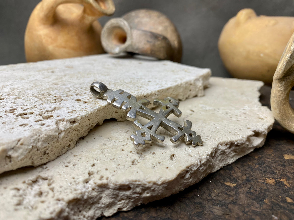 Mid 20th century Ethiopian silver crucifix. This may have been cut from a Marie Therese silver thaler, as the antique ones always are, however I believe that the style is more recent. Tests as silver. Plain on front side, plain back. Some wear at the head of the bail commensurate with its age. A wearable and collectable piece of jewellery.  Measurements: length including bail 6 cm