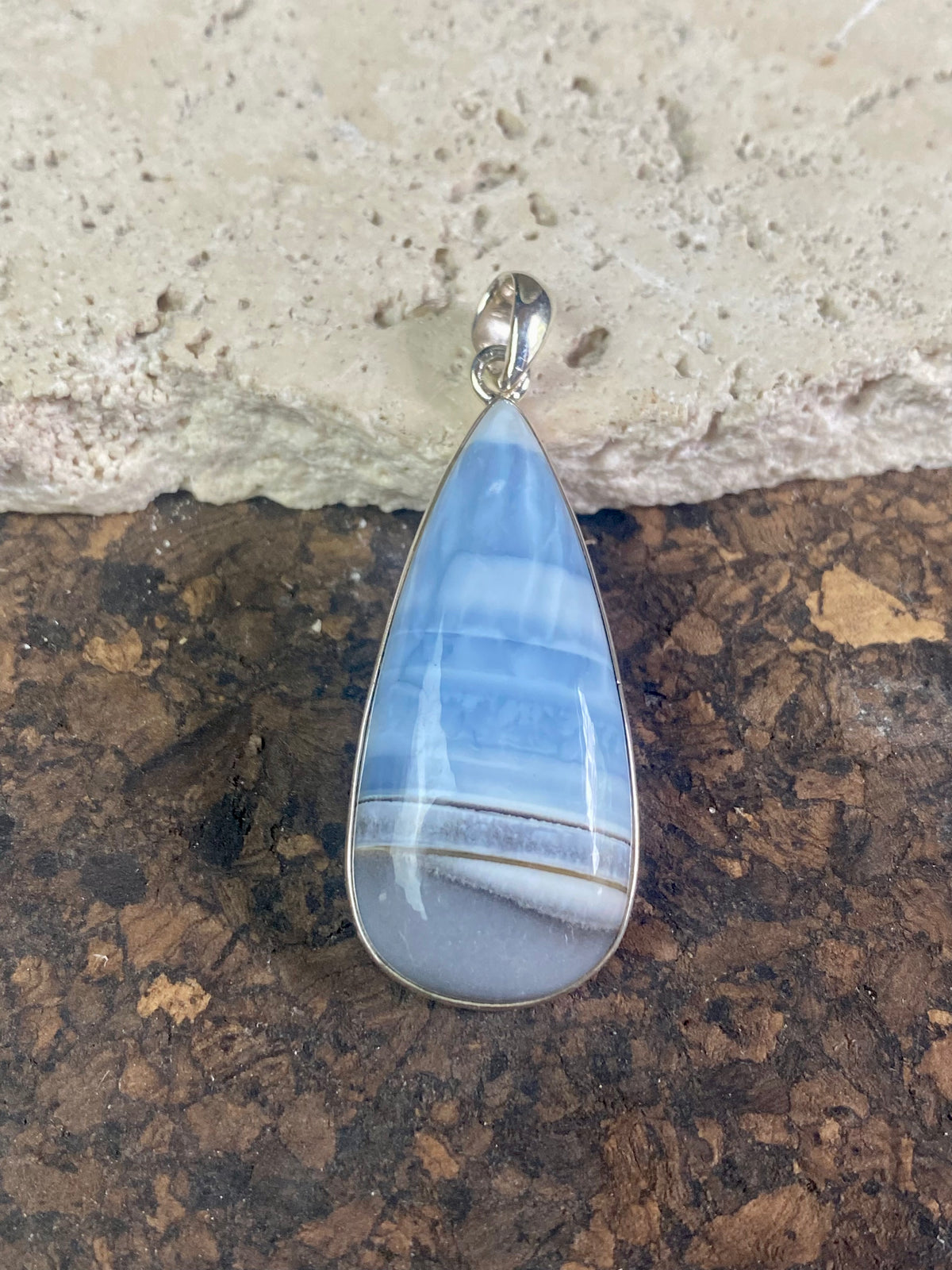 Natural banded blue opal pendants. Set off by sterling silver bezels, topped by generous sized bails large enough to accommodate a thick chain or cord. If you're looking for something a little bit different, this is statement jewellery at its finest.