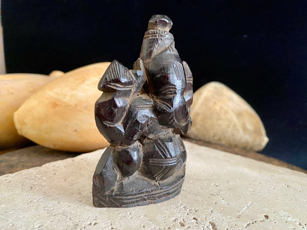 Small rosewood carving of Ganesh. Early 1900's, from east India. Two arms, seated, with his trunk to the left.  Height 9.5 cm, width  7 cm