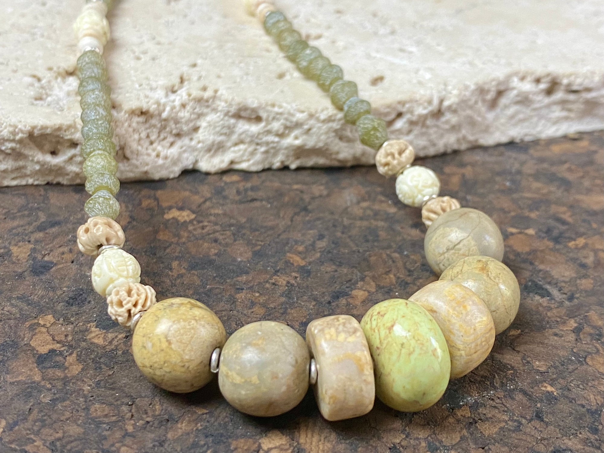 Tribally inspired stone necklace featuring prehnite, jasper, lotus root, carved white coral , glass and sterling silver.  Length 39.5 cm