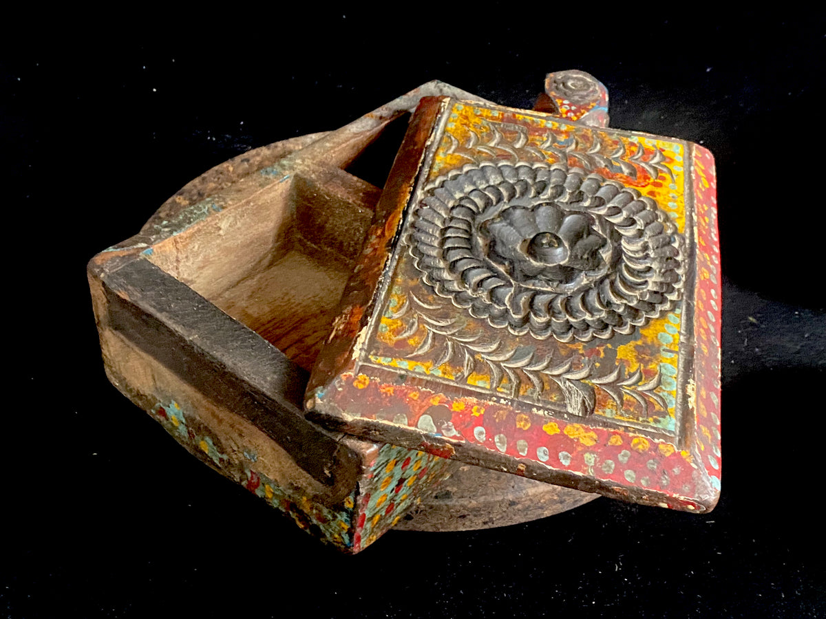 A lovely old southern Indian spice box with carved top, hand painted and swivel lid. Made from teak. Two compartments. This would make a lovely trinket box, key box, jewellery, watch or cufflink box. Circa 1880 - 1920. Handmade in southern India. Measurements: length 26 cm; depth 15 cm, height 9 cm.