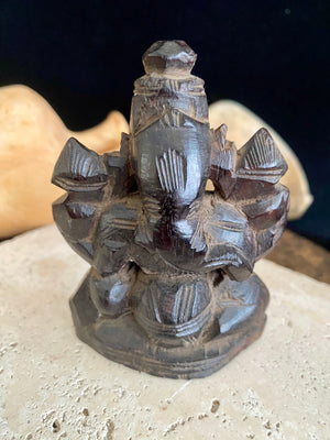 Small rosewood carving of Ganesh. Early 1900's, from east India. Two arms, seated, with his trunk to the left.  Height 9.5 cm, width  7 cm