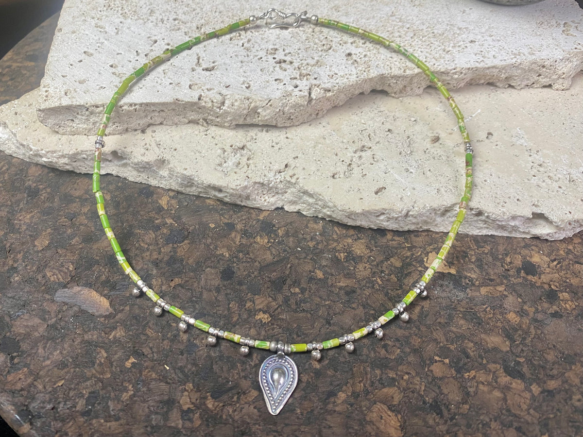 This very pretty necklace is made from tube cut imperial green jasper, highlighted with traditional handmade sterling silver Rajasthani ball beads and a tribal pendant. Finished with sterling silver findings and hook clasp. The pendant represents the shiva lingam/yoni. Length 40.5 cm