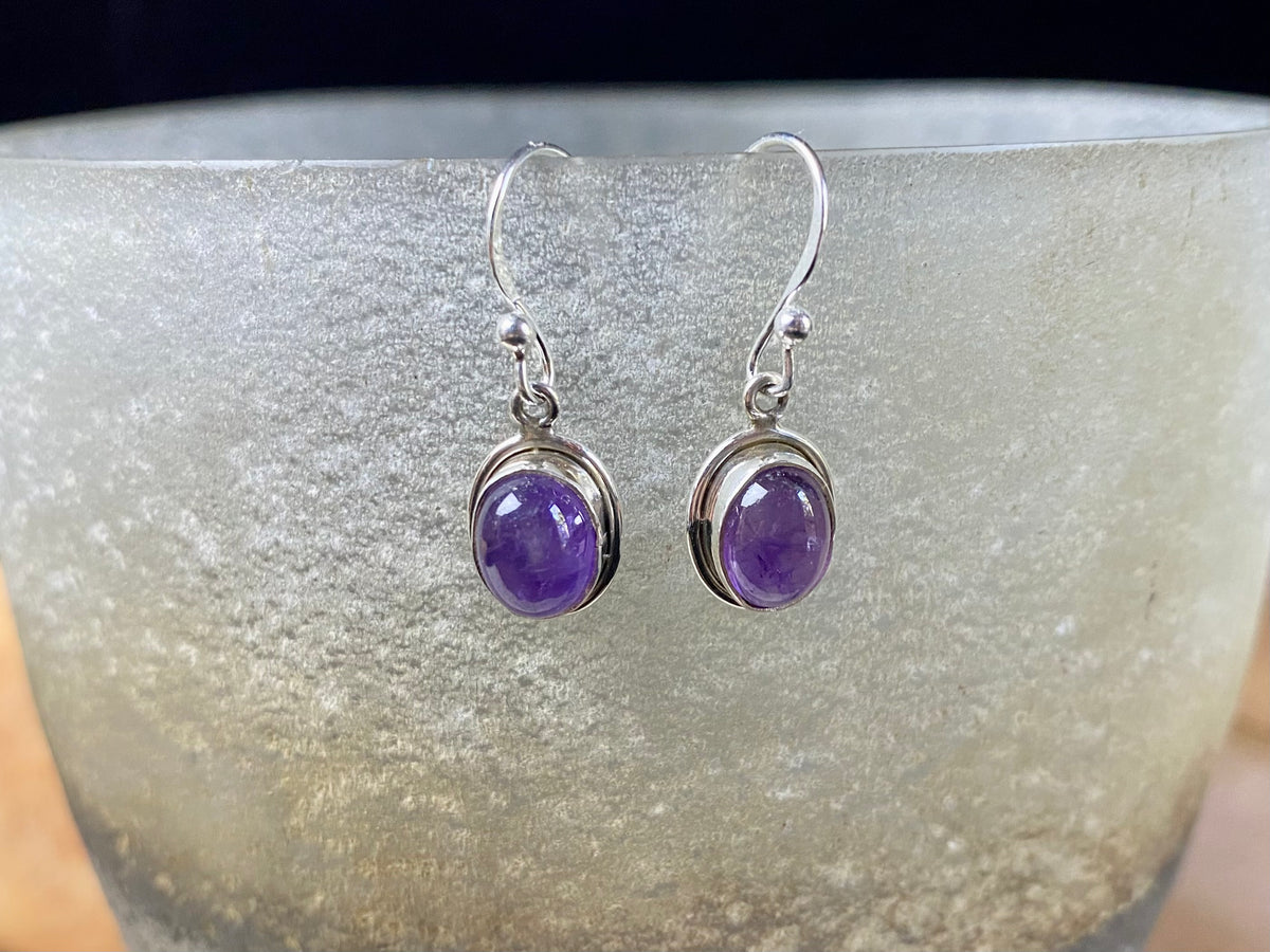 Simply elegant oval earrings with a small shadow box bezel to show off the beauty of the natural cabochon gemstones. Sterling silver hooks complete the look. Our earrings are open-backed to allow the light of the stones to show through. Length including hook 2.5 cm
