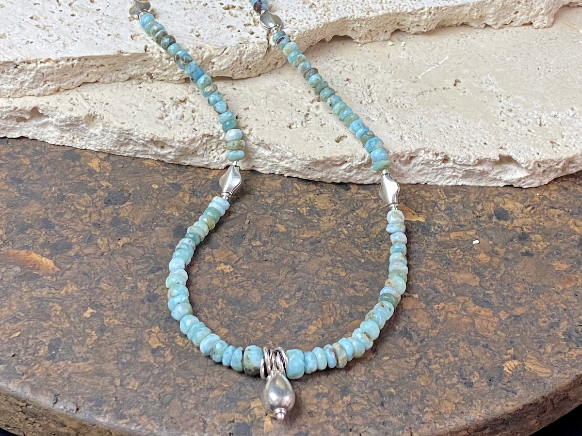 Light blue blue necklace of tumbled, facet cut graduated larimar, highlighted with Rajasthani silver beads and a beautiful central drop pendant. Finished with sterling silver findings and hook clasp. and a hook clasp. Measurements: 46 cm (18") length