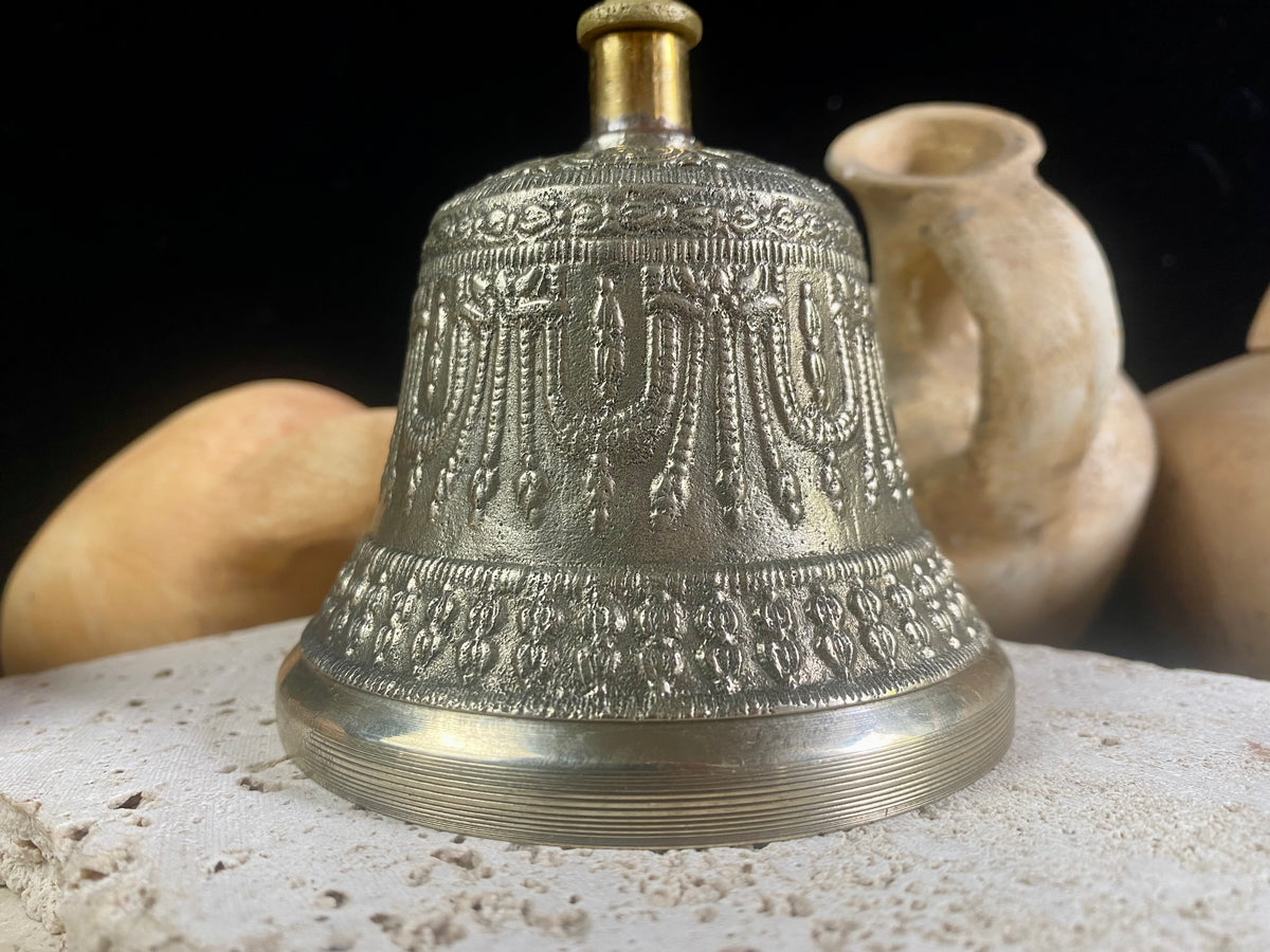 Tibetan Buddhist bells in two sizes. They feature fine detailing, are encircled with the mantra Om Mani Padmi Hum and are topped with the image of the Buddha and the dorje. These very high quality bells have a beautiful tone, the larger is deeper and richer, the smaller is higher and sweeter. Please watch our two videos to hear their sound.  Measurements:  Large: height 16 cm, diameter 9 cm Small: height 13 cm, diameter 7.5