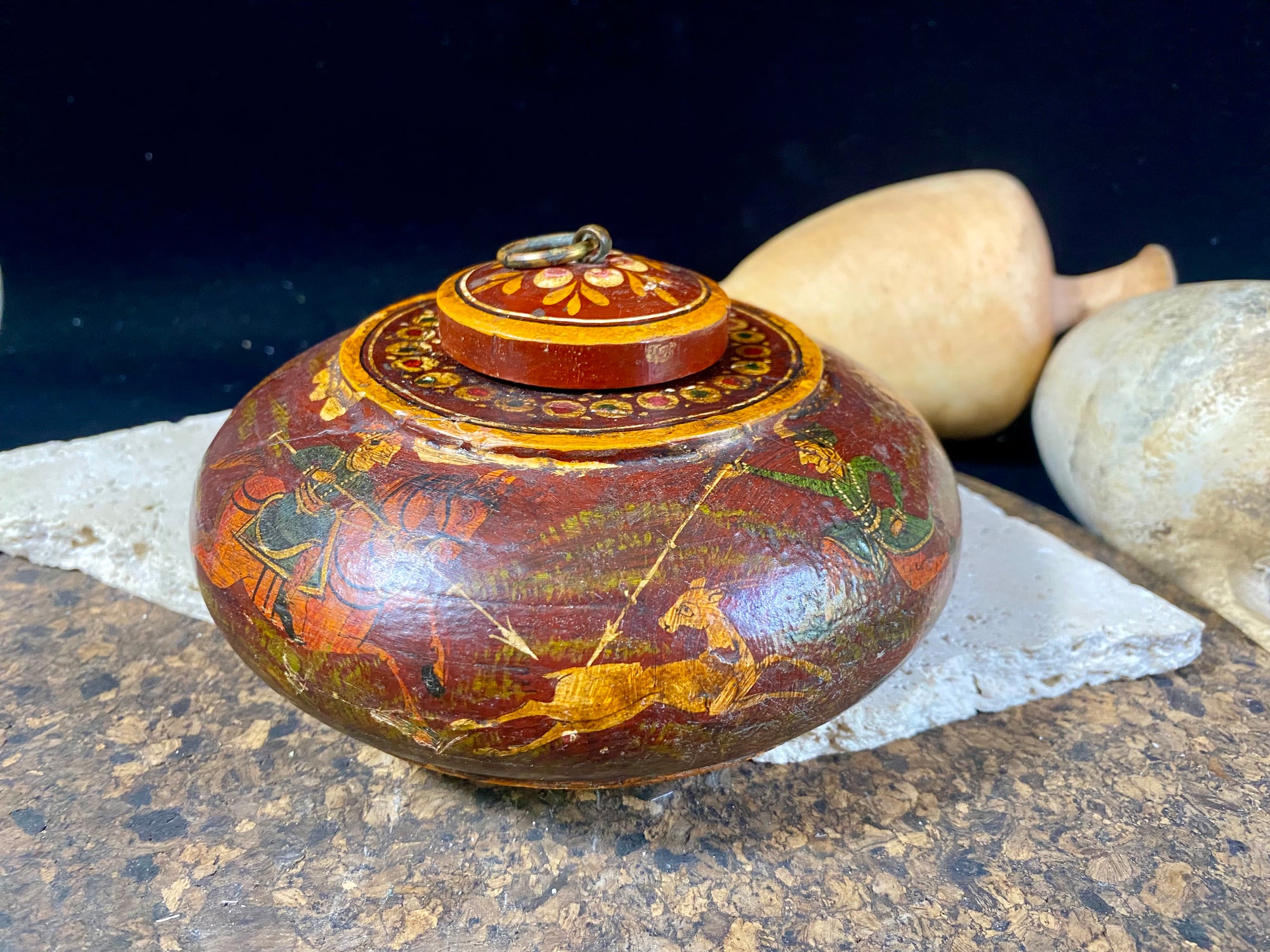 A beautiful low oval lidded bowl or box, traditionally called an opium pot because of its shape. Crafted from wood, then hand painted with hunting scenes. Hand made in Rajasthan, India. Measurements: diameter 14.5 cm, height 7 cm.