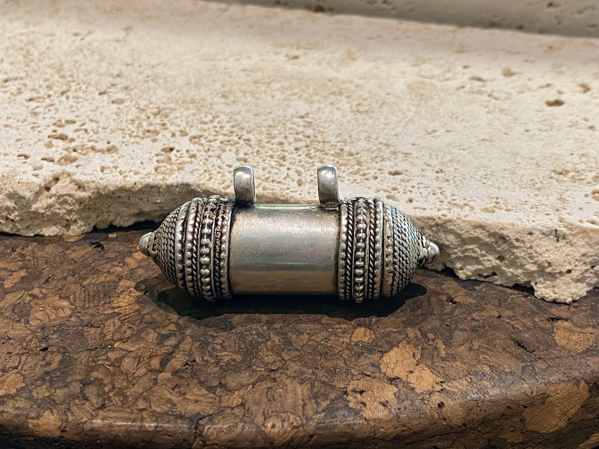 Amulet box or prayer box, these very solid pendants open at one end. Two large bails that even a thick cord or chain will pass through.  White metal.  Length 8 cm, diameter 1.8 cm