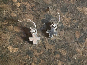 Tiny cross earrings. The body of the earring is made from a non-tarnishing white metal indistinguishable from silver, while the hooks are sterling silver. Lightweight and very easy to wear. Measurements: drop including hook 1.8 cm