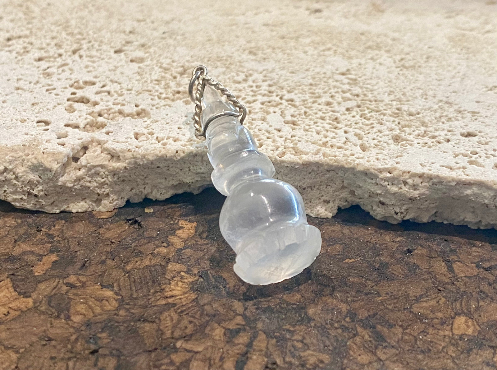 Hand carved rock crystal featuring the Buddhist stupa. Sterling silver bail. A stunning unisex pendant, would look beautiful on anyone.   Measurements: length including bail 4.7 cm, width 1.7 cm