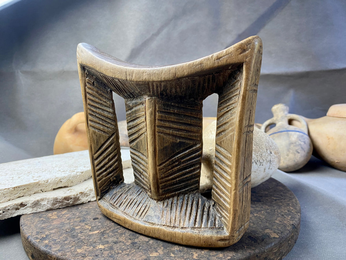 Old Oromo tribe wooden headrest from Ethiopia. Carved from a single piece of wood. Pre 1950. The patina and wear on this piece are appropriate to its age. In particular, note that the upper surface is darkened from use and the leading front edge is both lower than the rear edge and is also smooth from use.