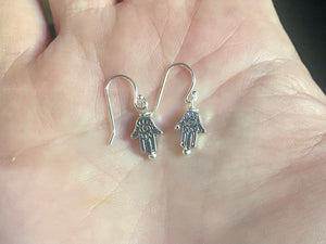 Stylish and very small hamsa earrings. The body of the earring is made from a non-tarnishing white metal indistinguishable from silver, while the pins and hooks are sterling silver. Lightweight and very easy to wear. Measurements: drop including hook 2 cm