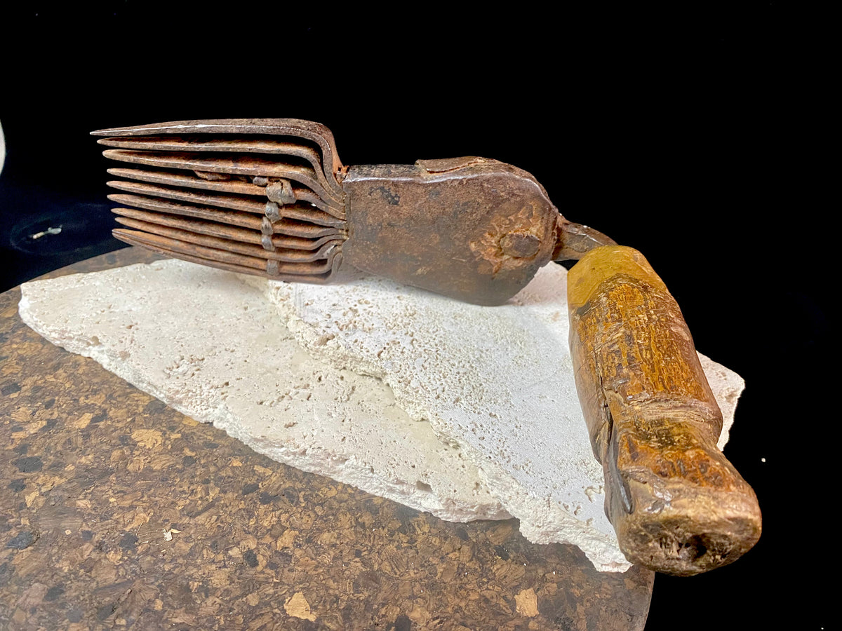 Used for the manual tamping down of carpet threads during the weaving process on a hand loom. Heavy iron with a wood handle. 19th century or older. Afghanistan.  Measurements: length 26 cm, width 6.5 cm, height 10 cm