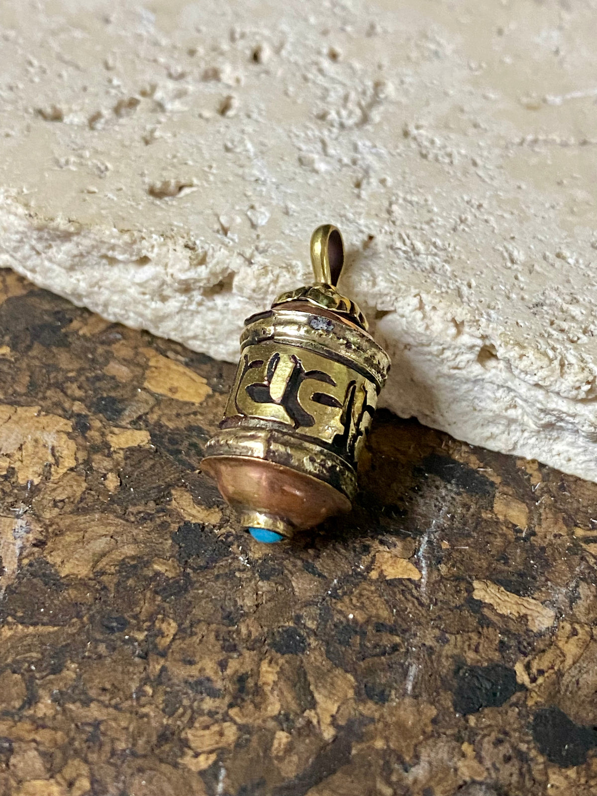 Miniature prayer wheel or prayer box designed to be worn as a pendant, a charm on a bracelet or added to a keyring. Brass and copper, containing a prayer scroll. Height 3 cm. Mantra is Om Mani Padme Hum, prayer to the Compassionate Buddha