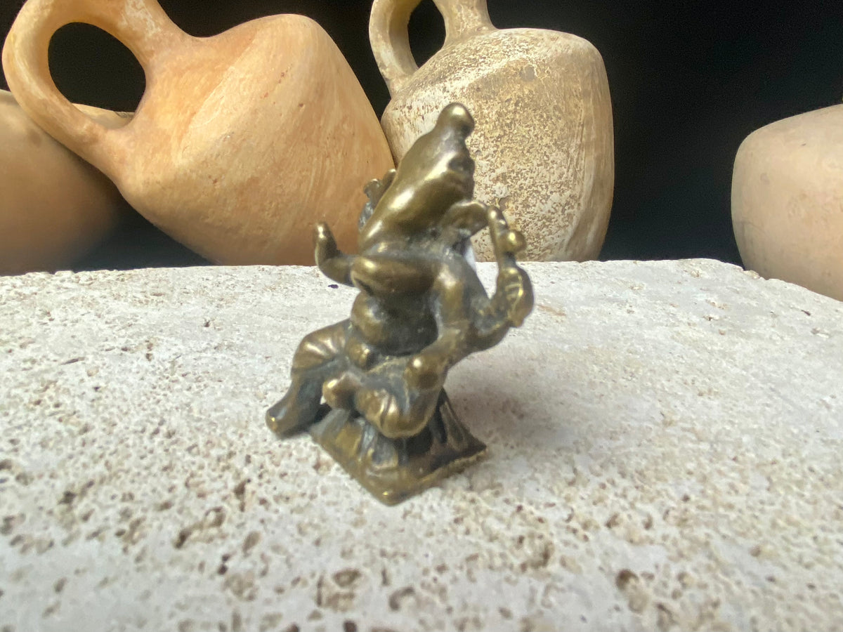 This exquisite mini Ganesh statue features fine, elegant features, and a face softened by many years of rubbing and worship. A beautiful piece. Approximately 100 years old, early 20th century, India, brass alloy.  Measurements: height 6.5 cm, width 3.2 cm, depth 2.5 cm