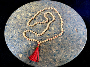 Women or men’s mala necklace, made from small fine rudraksha beads with five mukhi. Knotted between each bead with red thread and finished with a red tassel. As per a standard Buddhist mala, it contains 108 beads. From India