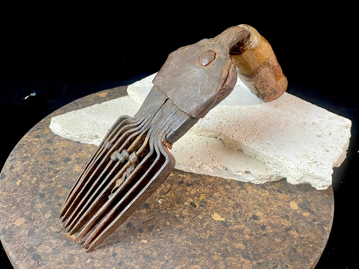 Used for the manual tamping down of carpet threads during the weaving process on a hand loom. Heavy iron with a wood handle. 19th century or older. Afghanistan.  Measurements: length 26 cm, width 6.5 cm, height 10 cm