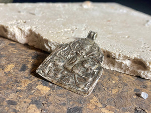 This large Durga&nbsp;amulet &nbsp;dates to the early 20th century, the bail has been replaced at some stage as it most likely wore through. Lightweight and easy to wear, this is a beautiful amulet.  Measurements: height 4.8 cm including bail, width 3.5 cm