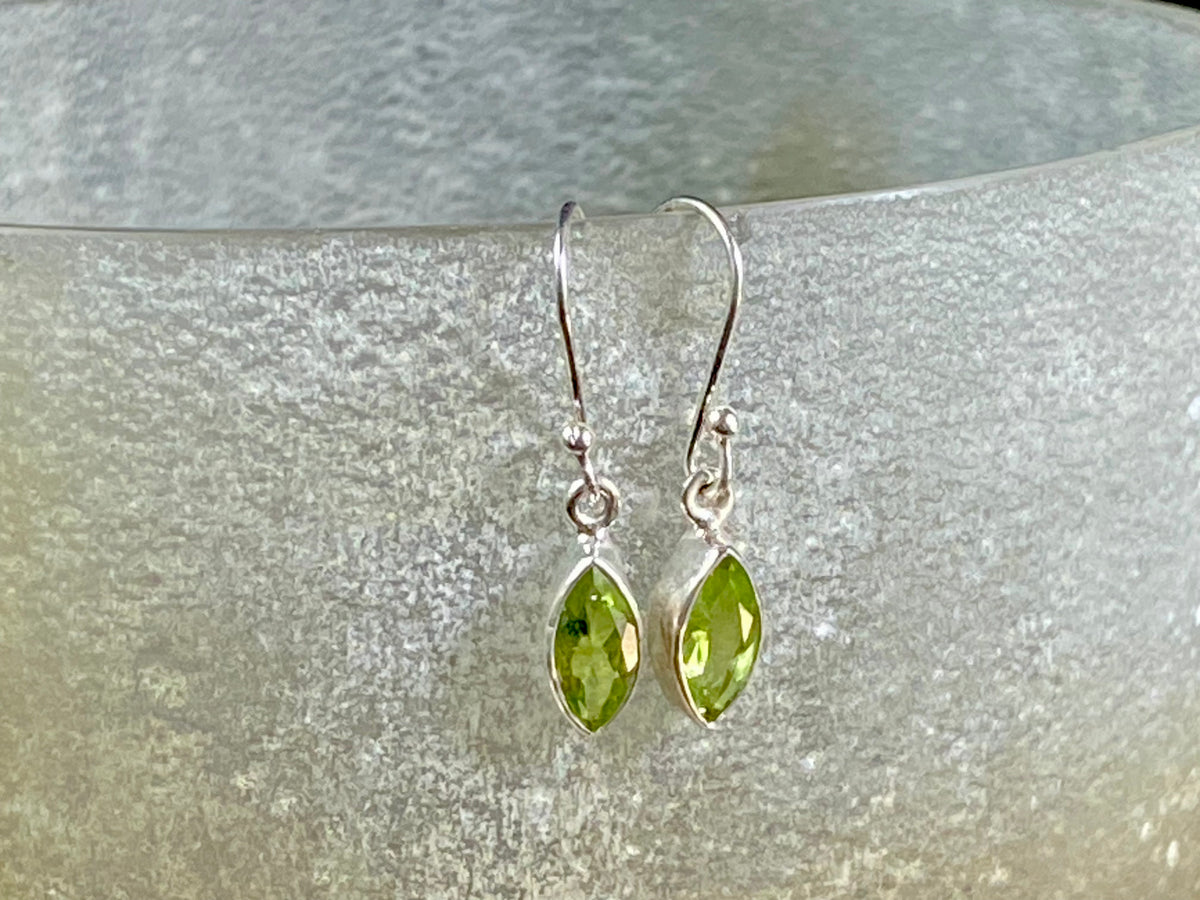 Beautiful peridot earrings featuring gem quality facet cut peridot stones in three shapes, teardrop, oval or leaf. A sterling silver mount and hook completes the look. These earrings are open at the back to allow light to shine through the stones. Around 3 cm length including hook