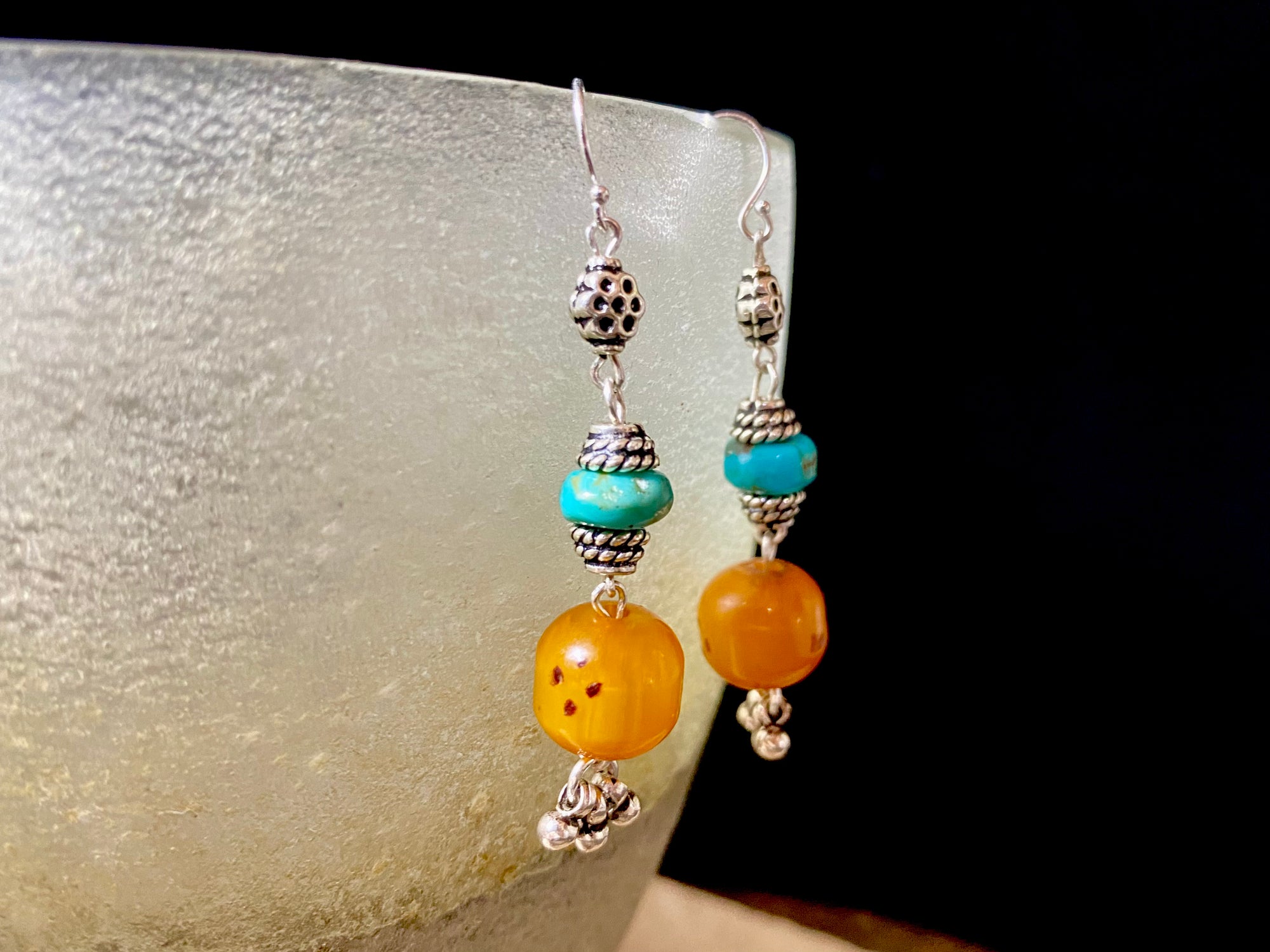 These exotic earrings were created from vintage copal amber beads topped with Arizona turquoise and handmade sterling silver beads, finished with sterling silver hooks.These are a one-off earring design that are very light and easy to wear. Length 5.8 cm including hook