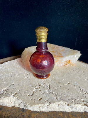 Small cranberry glass perfume bottles with hinged flip top brass lids.&nbsp;