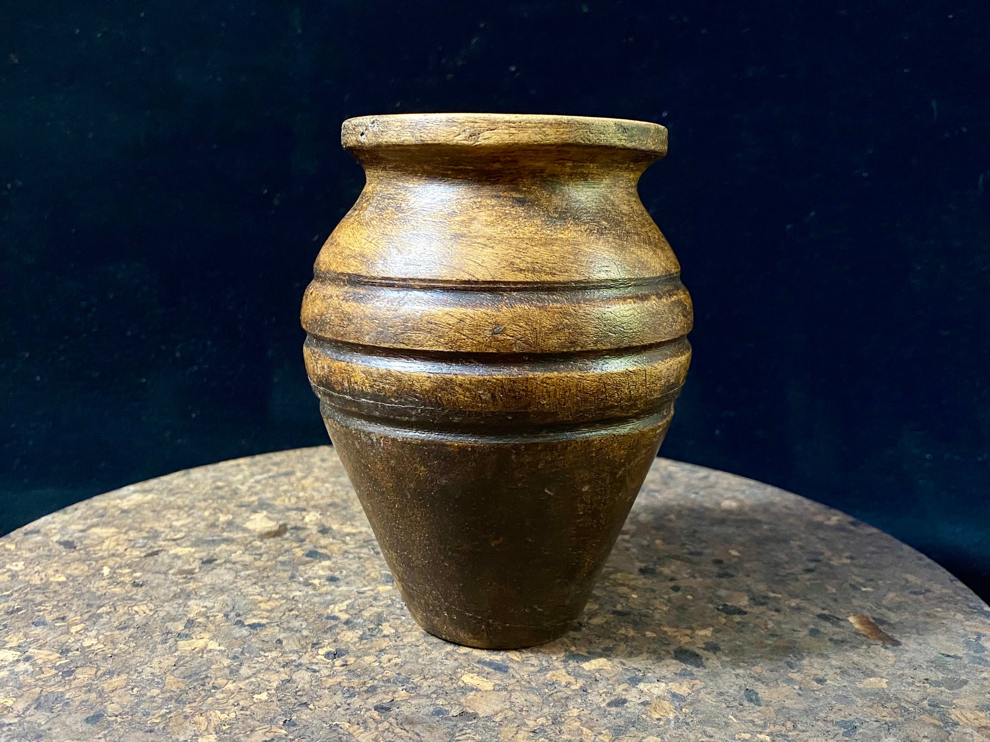 A small shaped wood pot with three carved lines of decoration. Carved from hardwood, most likely rosewood. Late 20th century vintage. Measurements: diameter at widest point 9 cm, diameter of opening 4.5 cm, height 12 cm
