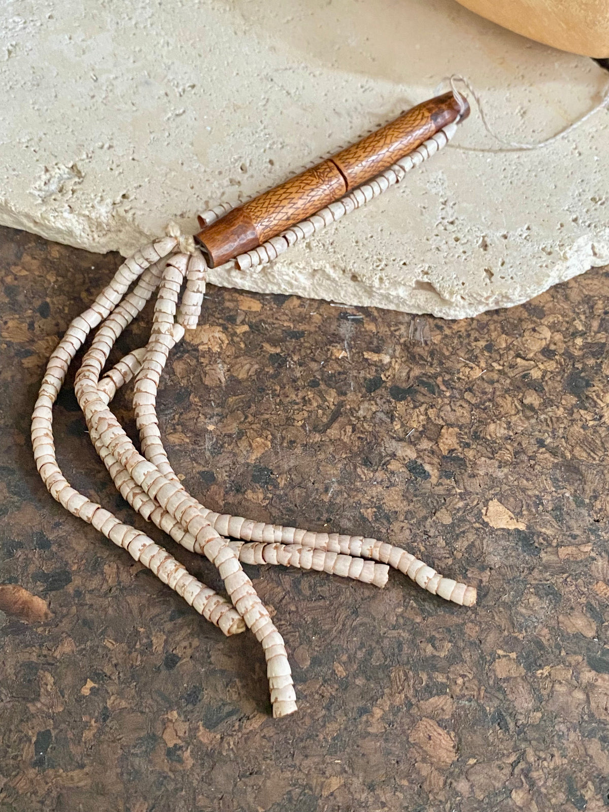 This is a vintage wood sewing needle case from northern Thailand, from the Ahka tribe. This beautiful, old and rare vintage piece is highly decorated and made from bamboo, etched, stained with red betel juice and finished with a long fringe of Jacob's tears. Length 24.5 cm with fringe, length of tube 9 cm
