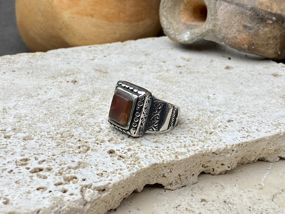 An elegant ring featuring a beautiful dark carnelian stone. The stone shows some wear commensurate with its age. Afghanistan, early to mid 20th century. Can be worn by either men or women. Measurements: Ring face 1.6 x 1.3 cm, inner diameter 18.5 mm | Size 8.5 | No 19