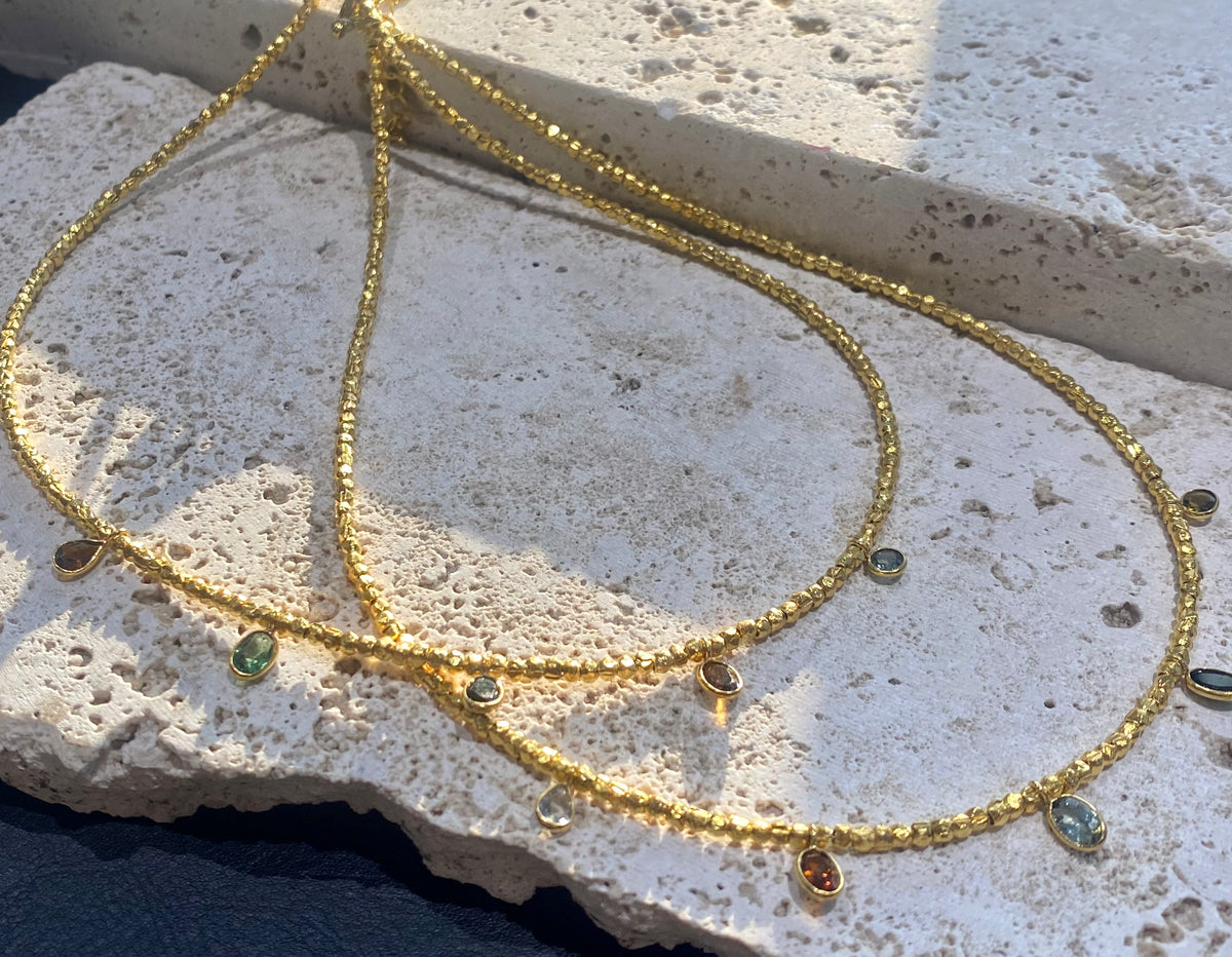 Vibrant gemstones adorn this elegant multi charm necklace. Plated 22k gold over brass, the multicoloured gemstones are evenly spaced and bezel-set to highlight the beauty of each gemstone. This necklace is designed to be worn short, but comes with an extension chain so you can set the length according to your neckline. Measurements: length 41 cm, with extension chain 45.5 cm