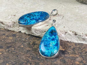Unusual and striking azurite pendants. Set off by sterling silver bezels, topped by generous sized bails large enough to accommodate a thick chain or cord. If you're looking for something a little bit different, these pendants are stunning.