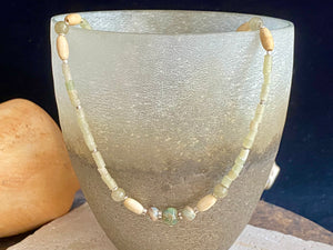 This unique choker features beautiful vintage beads from the Kashgar collection - blue green turquoise centre bead, Ethiopian opal, Bone beads from Burma, Pale green chrysoprase beads, Green serpentine tube beads from Afghanistan and 925 sterling silver detailing and lobster clasp. Length 40.5 cm