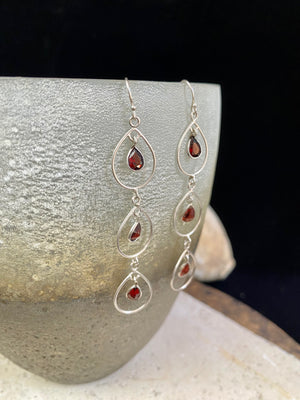 Beautiful garnet earrings featuring a sterling silver chandelier mount with three perfect facet cut teardrop garnets of superb quality. Light and easy to wear.  Measurements: 7 cm including hook 