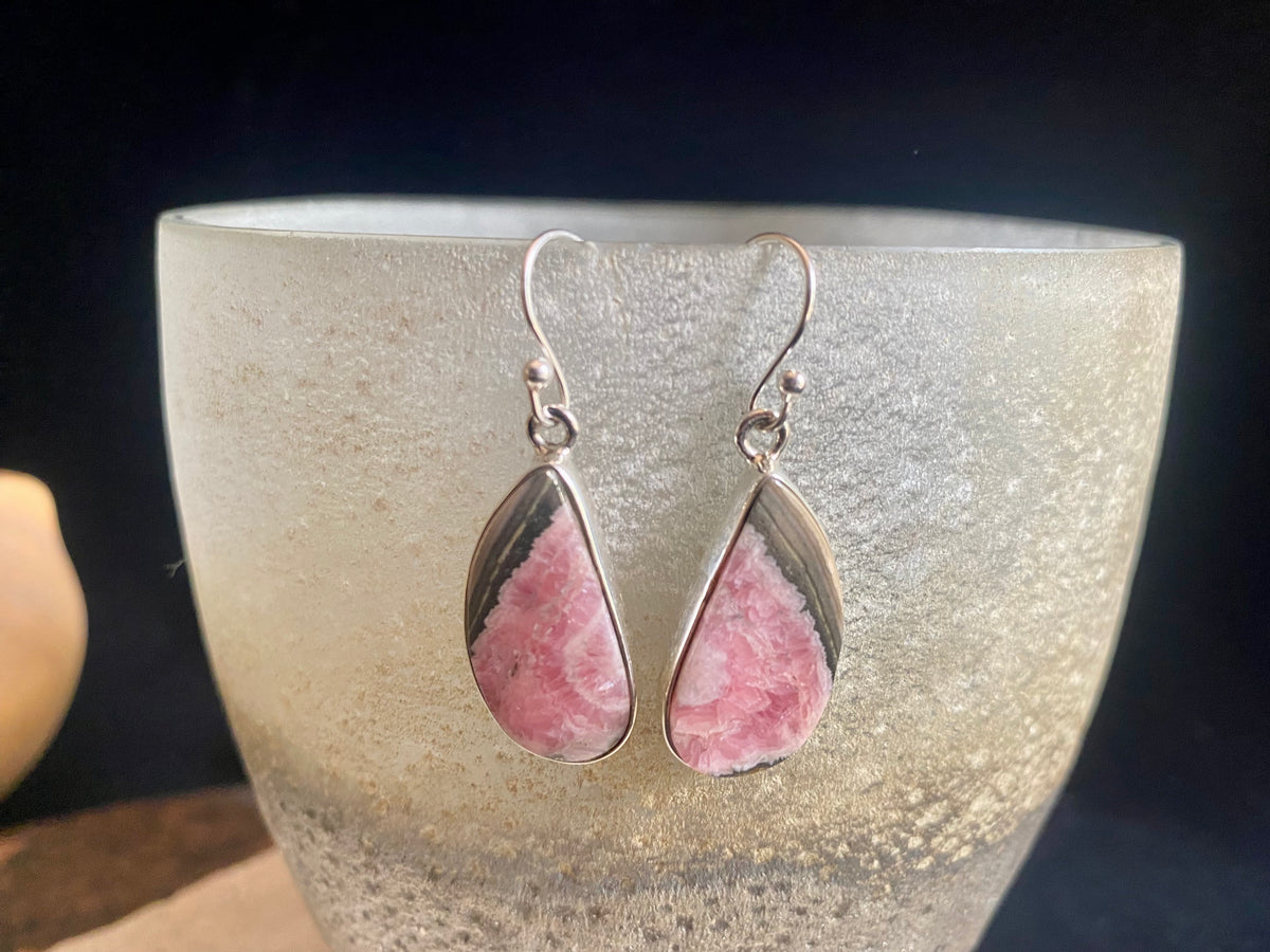 The most beautiful rhodochrosite we've ever seen. Every piece tells a story, and all earring pairs feature perfectly matched stones set in sterling silver bezels. Finished with sterling silver hooks.