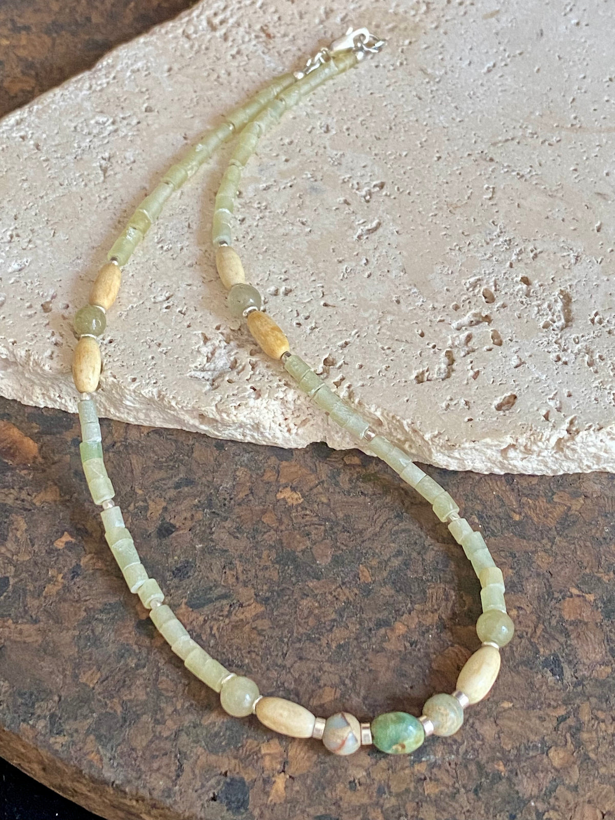 This unique choker features beautiful vintage beads from the Kashgar collection - blue green turquoise centre bead, Ethiopian opal, Bone beads from Burma, Pale green chrysoprase beads, Green serpentine tube beads from Afghanistan and 925 sterling silver detailing and lobster clasp. Length 40.5 cm