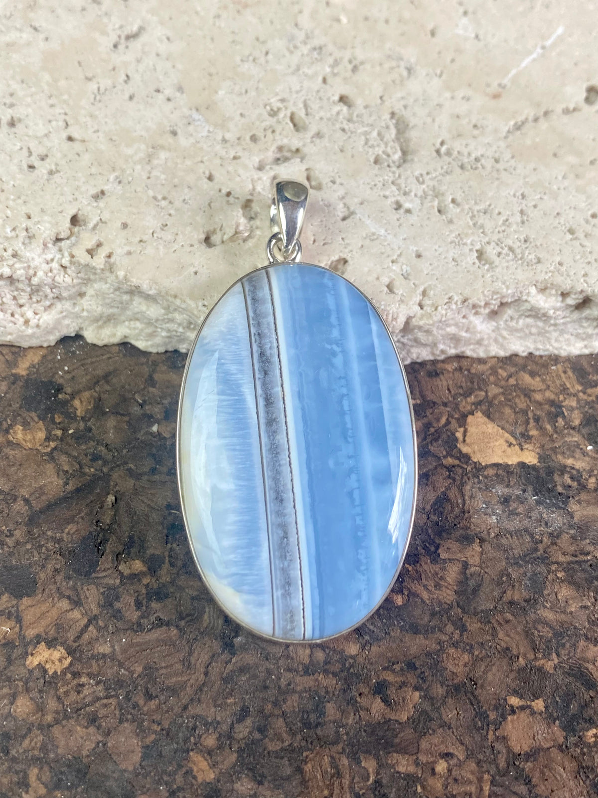 Natural banded blue opal pendants. Set off by sterling silver bezels, topped by generous sized bails large enough to accommodate a thick chain or cord. If you're looking for something a little bit different, this is statement jewellery at its finest.